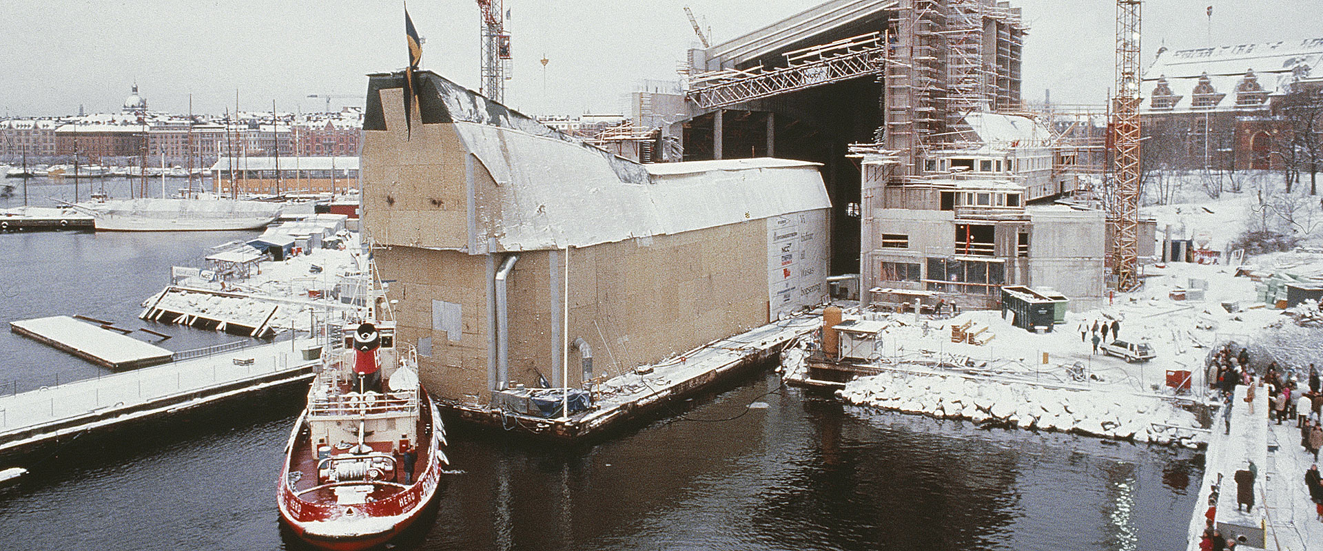 Vasa är inklädd i masonitskivor och bogseras in i nya museet genom en stor öppning.