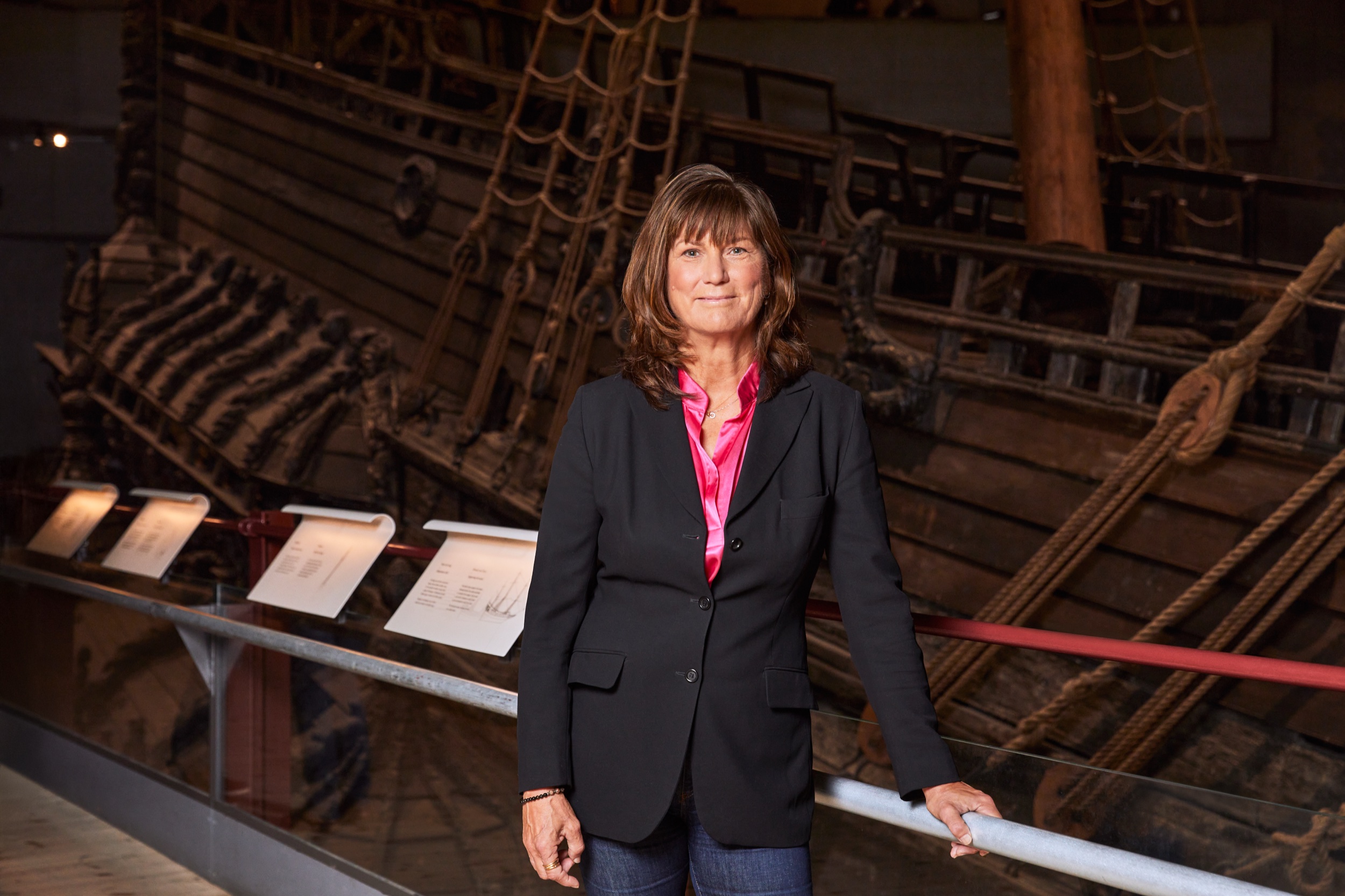 Brown haired woman in a suit in front of the ship Vasa.