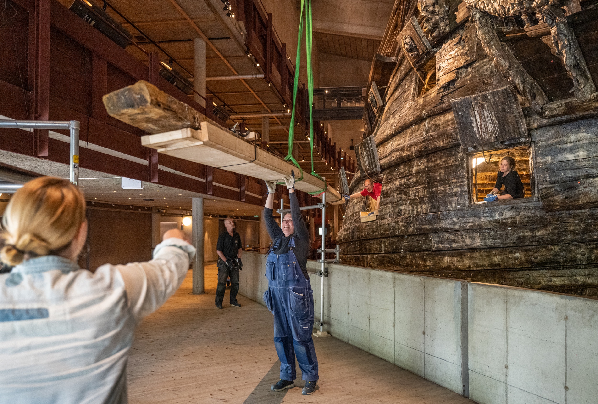 En däcksplanka från Vasa tas ut genom en kanonport på styrbords sida.